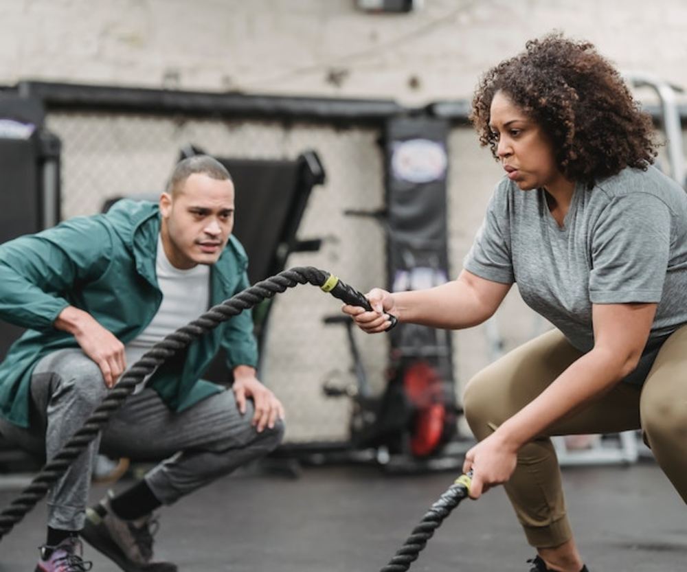 Woman is training with a personal trainer in the gym