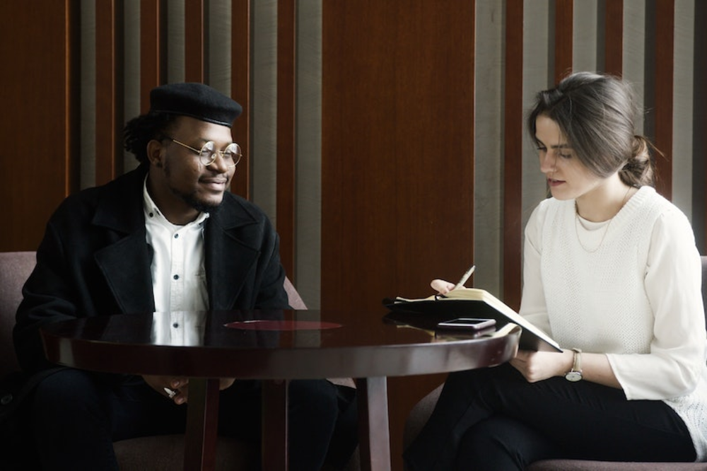 A man and a woman sitting on opposite sides of the table
