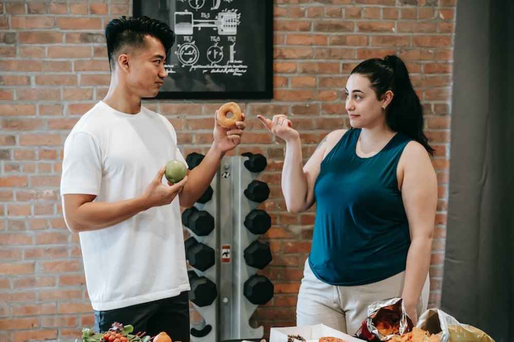 A fitness profession guiding his client with nutrition and personal training