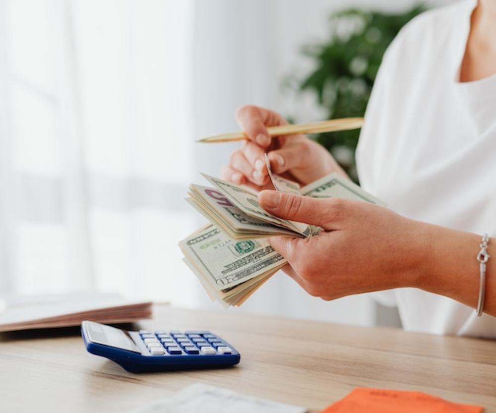 Woman Counting Money with Calculator