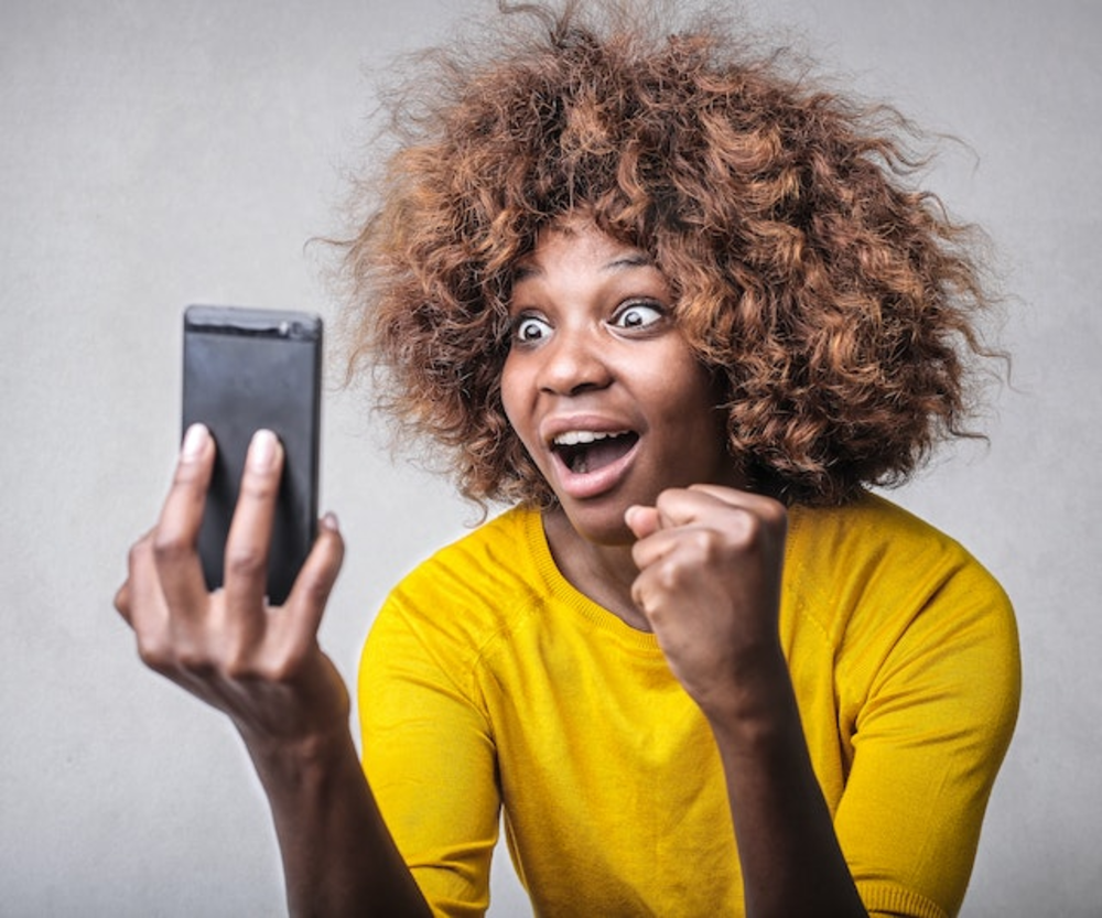 Woman look at the phone’s screen excitedly