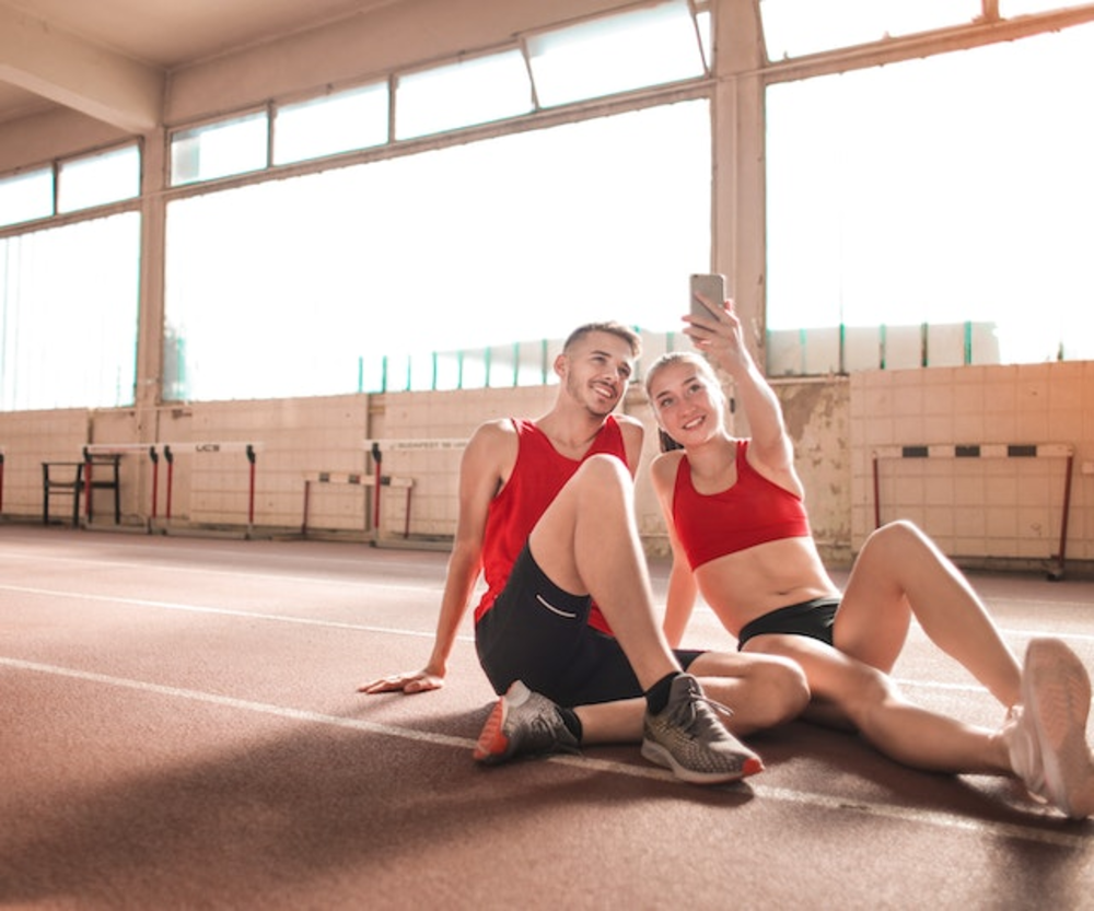 Sporty couple taking selfie on gym