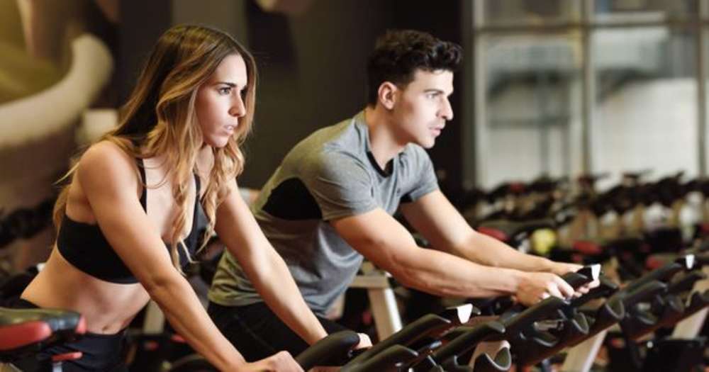 Woman and man have a workout session together at the gym