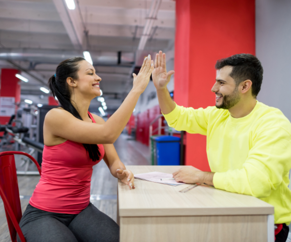 Personal Trainer und Kunde high five