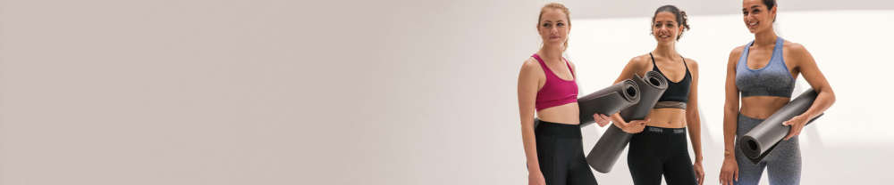 Gruppe Frauen halten Yogamatte fest