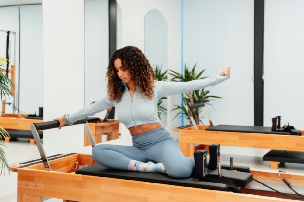 Vrouw voert een gecontroleerde Pilates-oefening uit op een mat voor verbeterde core-stabiliteit.