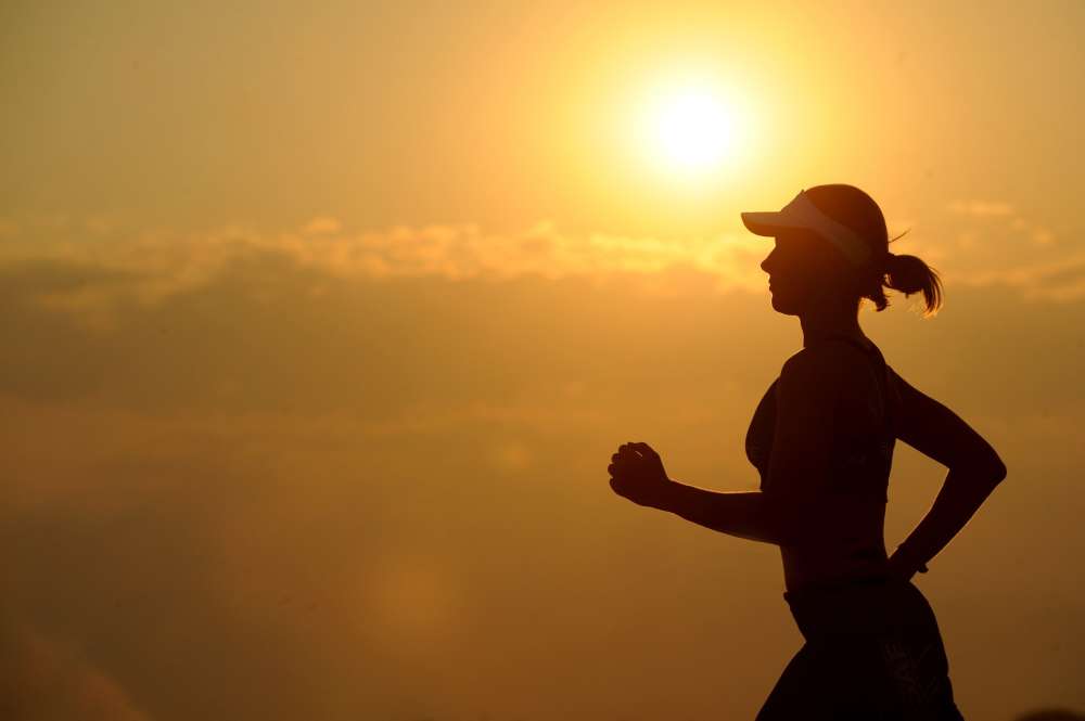 Mujer corriendo al aire libre disfrutando de la naturaleza de forma eco