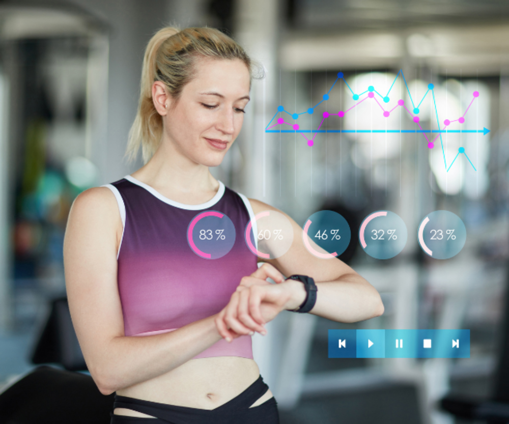 Una mujer mirando su smartwatch en un gimnasio con métricas digitales de salud mostradas.