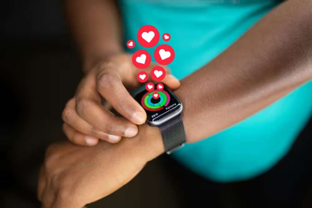 Close-up of a person checking their smartwatch with animated hearts, showing activity rings progress.