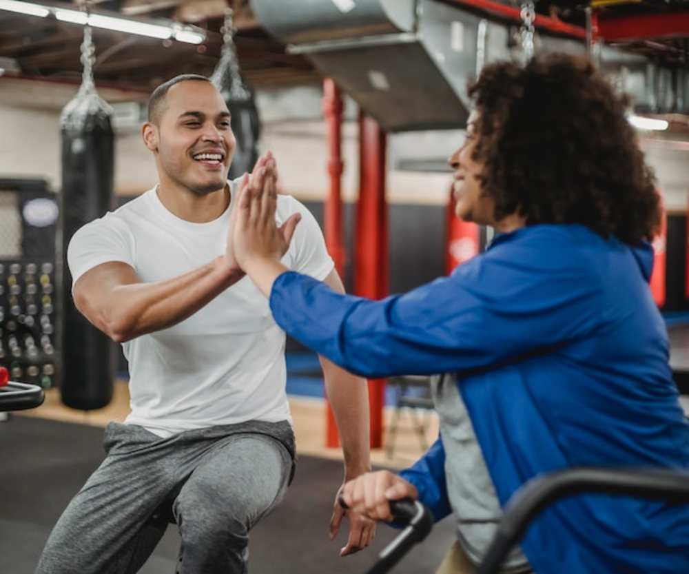 Woman and men in the gym giving high five to each other