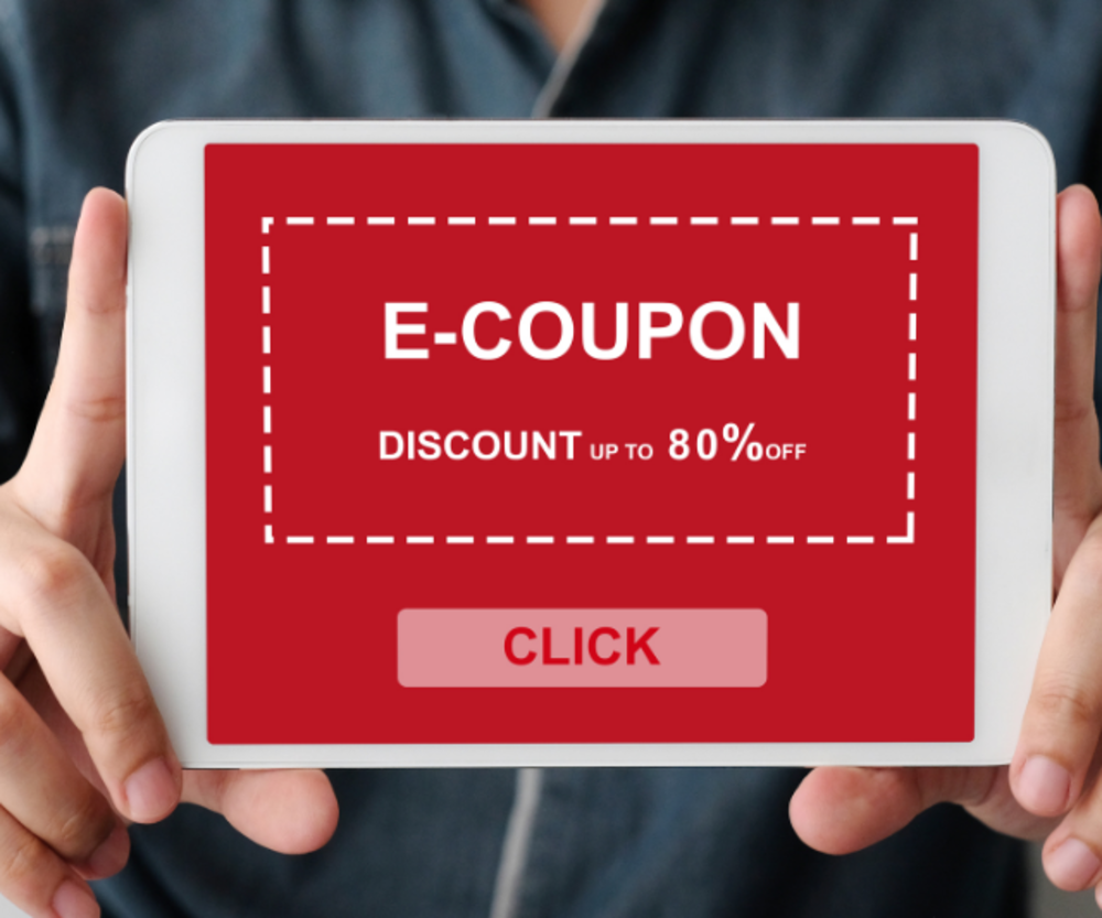 Un primer plano de una persona sosteniendo un dispositivo con un cupón electrónico mostrado en la pantalla que ofrece hasta un 80% de descuento.