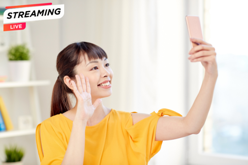 Smiling Asian woman capturing a selfie with her smartphone.