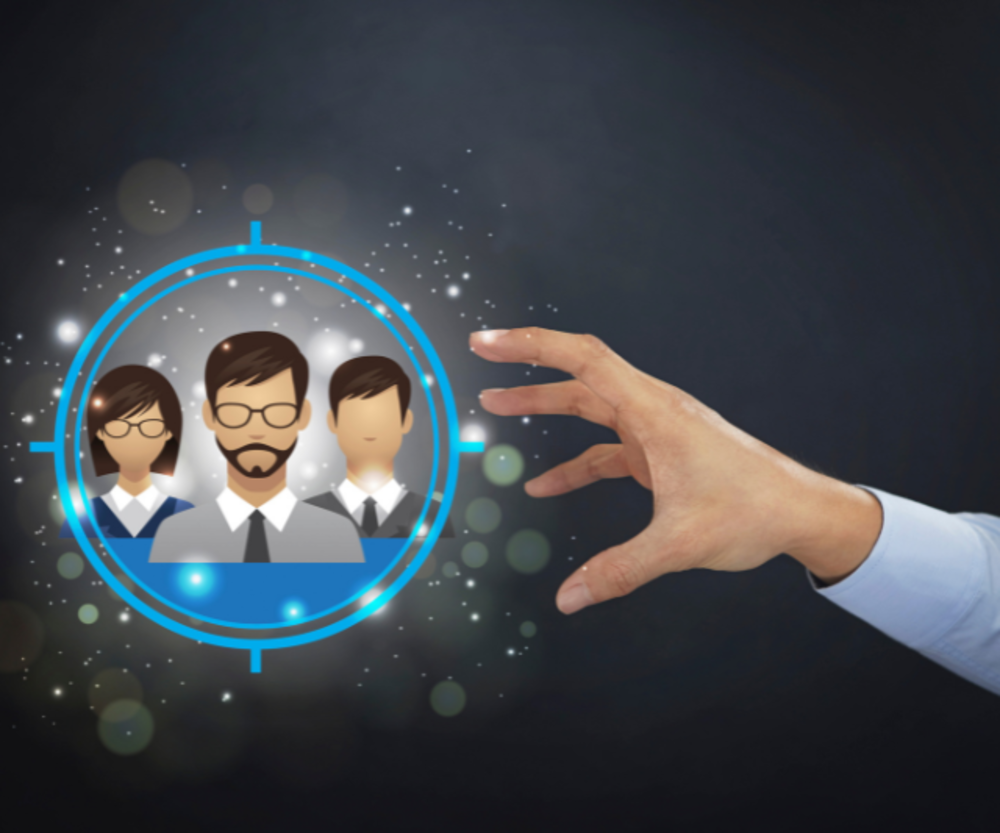 Hand reaching towards a holographic projection of three office workers.