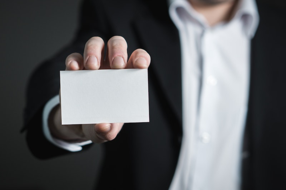 A man holding a blank business card