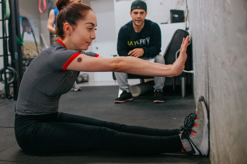 Fitness trainer guiding a client through a home workout on Craiyon