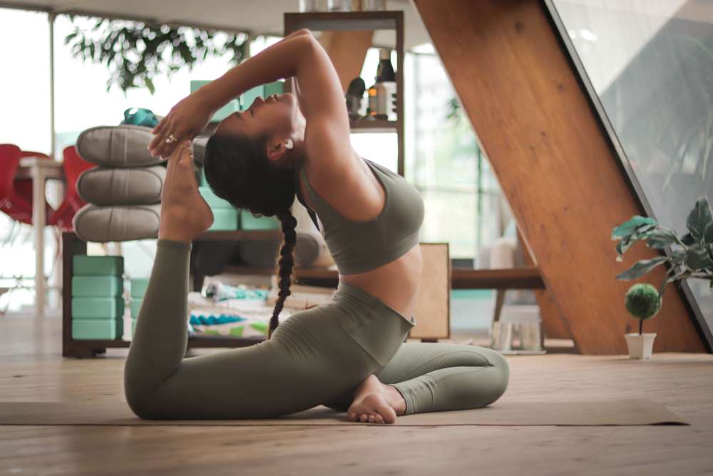 Mujer practicando rutinas de yoga en casa.