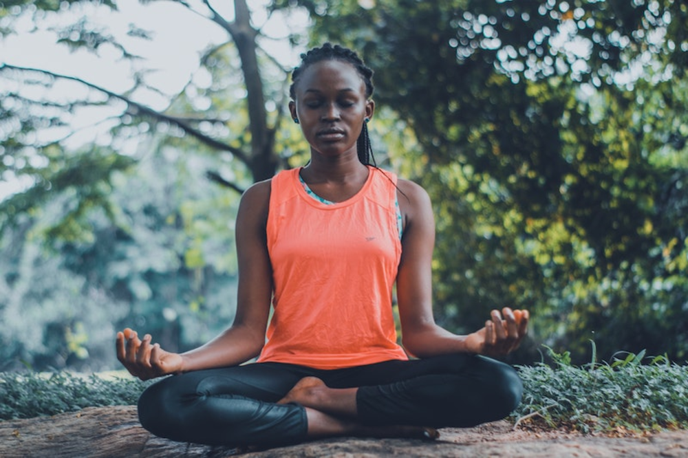 A woman meditating out in the nature