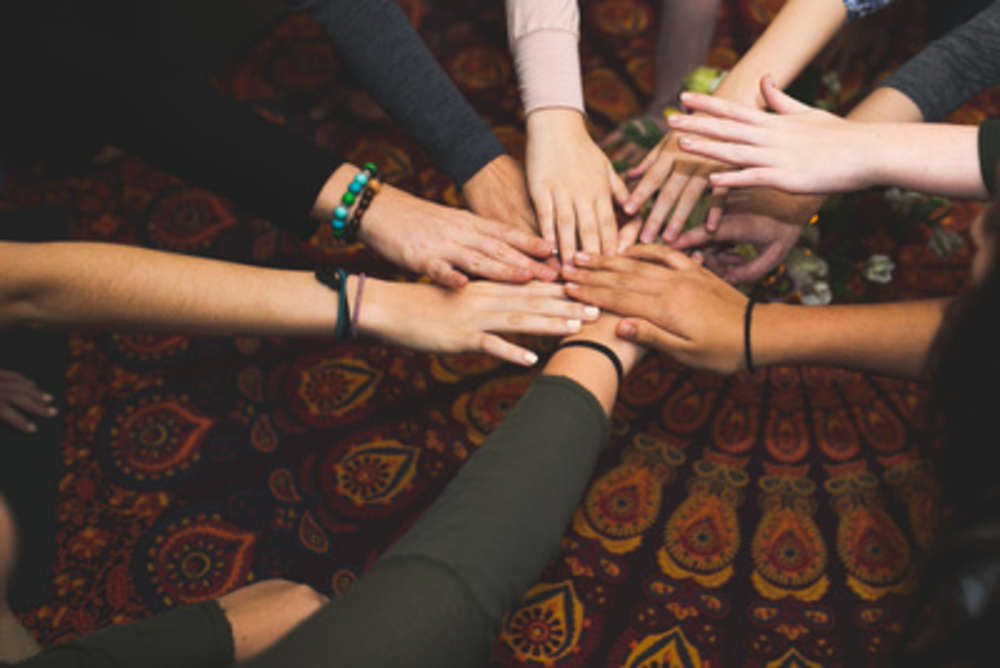 Group of people holding hands in a circle
