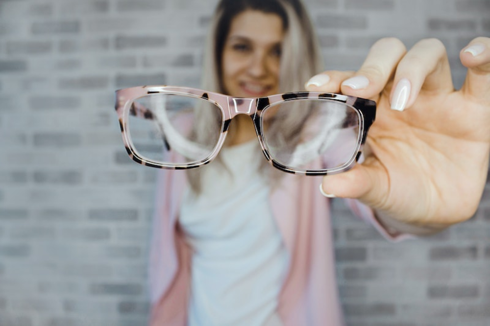 A woman holding a spectacles in her hand