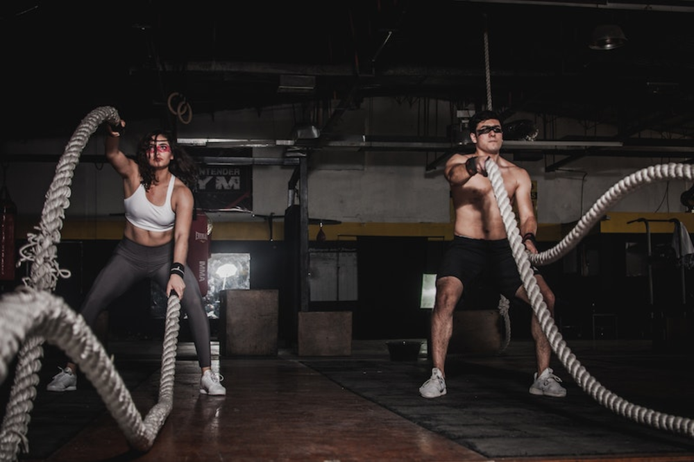 Woman and man using ropes to workout 