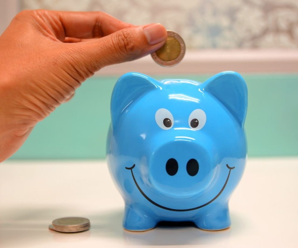 A person putting money into a piggy bank