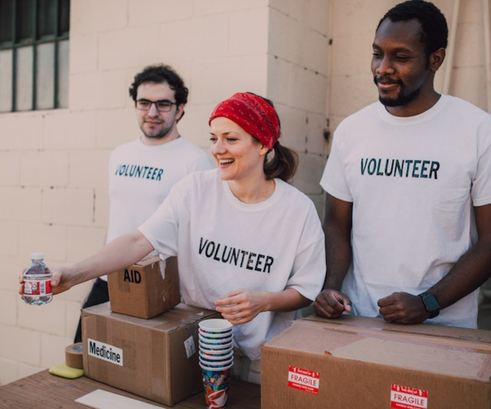 three volunteers give away the medicine and water