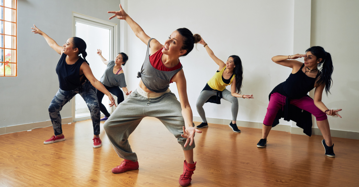 Cinco mujeres están teniendo una lección de baile en el estudio de baile