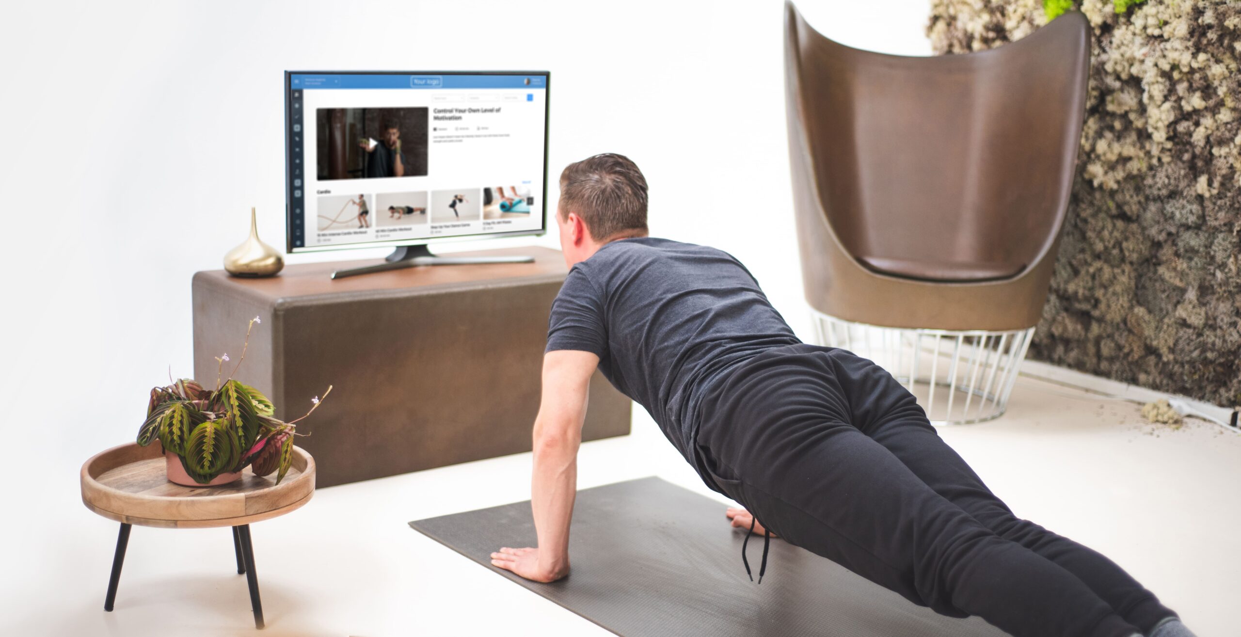 Hombre haciendo ejercicio en casa siguiendo el entrenamiento de vídeo en el televisor