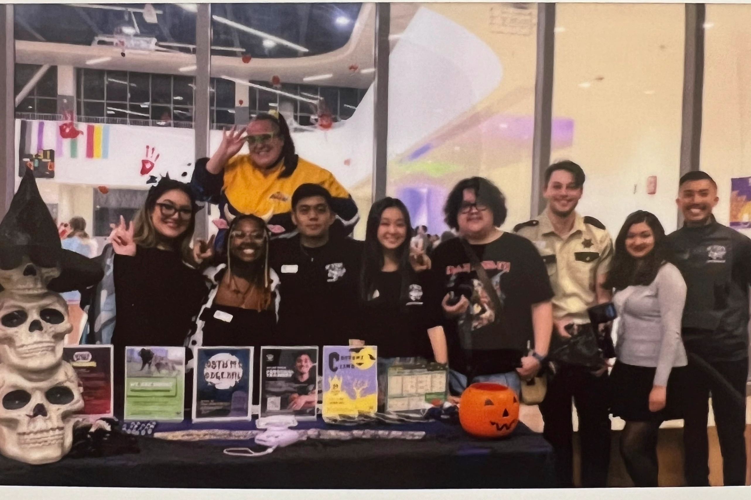 The Campus Recreation student staff behind a table at a Halloween event, with printed flyers standing on the table.