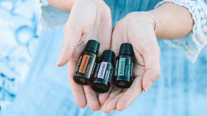 Woman holding aromatherapy oils.