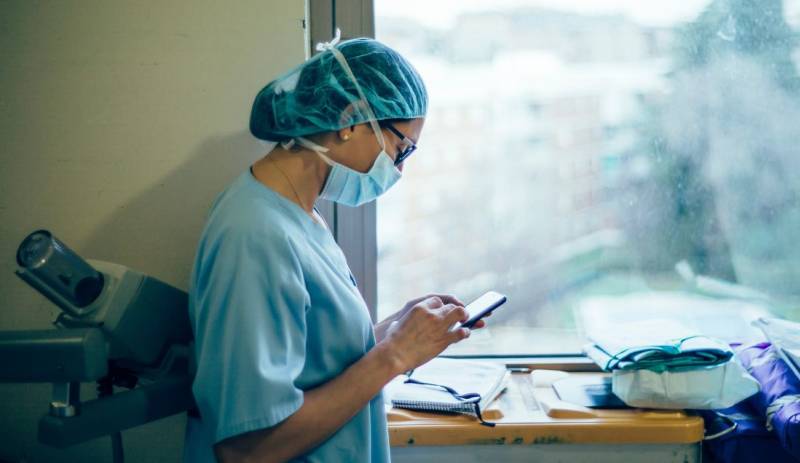 Clinician on her smartphone checking prescription