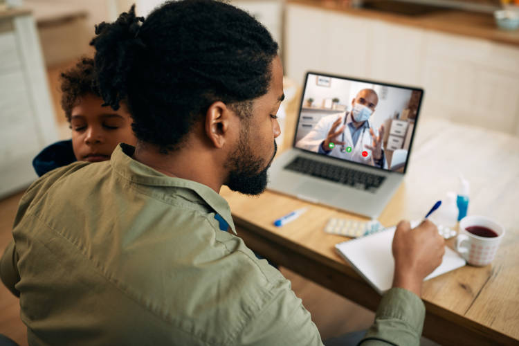 Black father having video call with pediatrician and