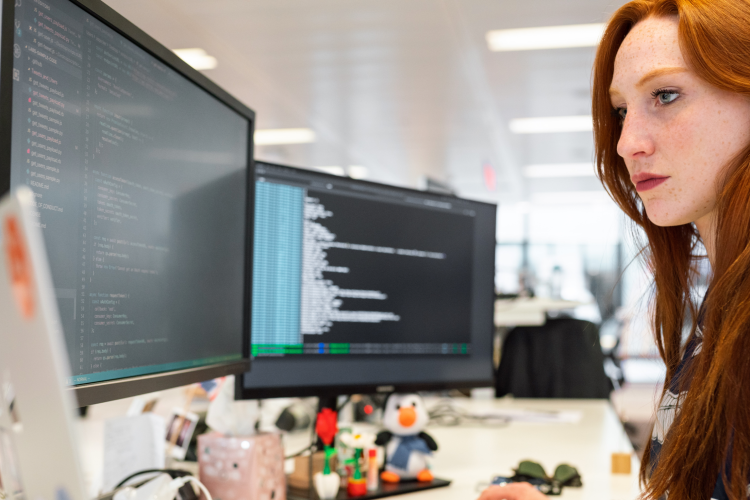 Woman working at desk with two screens, technology modernisation