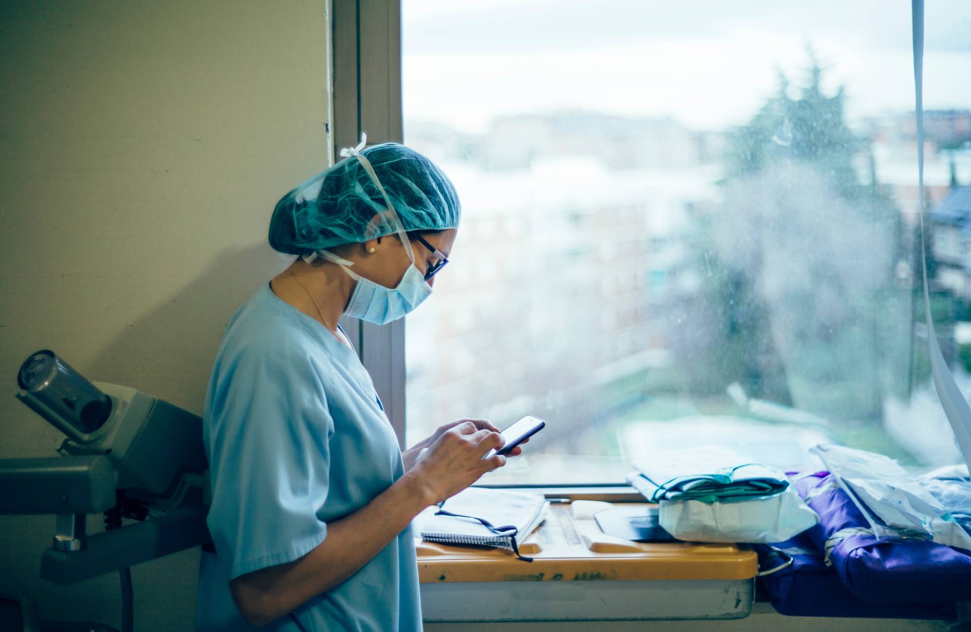 Female surgeon doctor consults the mobile phone before operation.