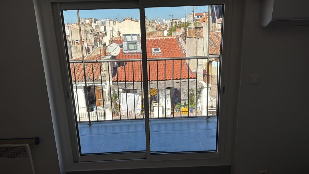 Baie coulissante à deux vantaux ouvrant sur un balcon, vue de l’intérieur