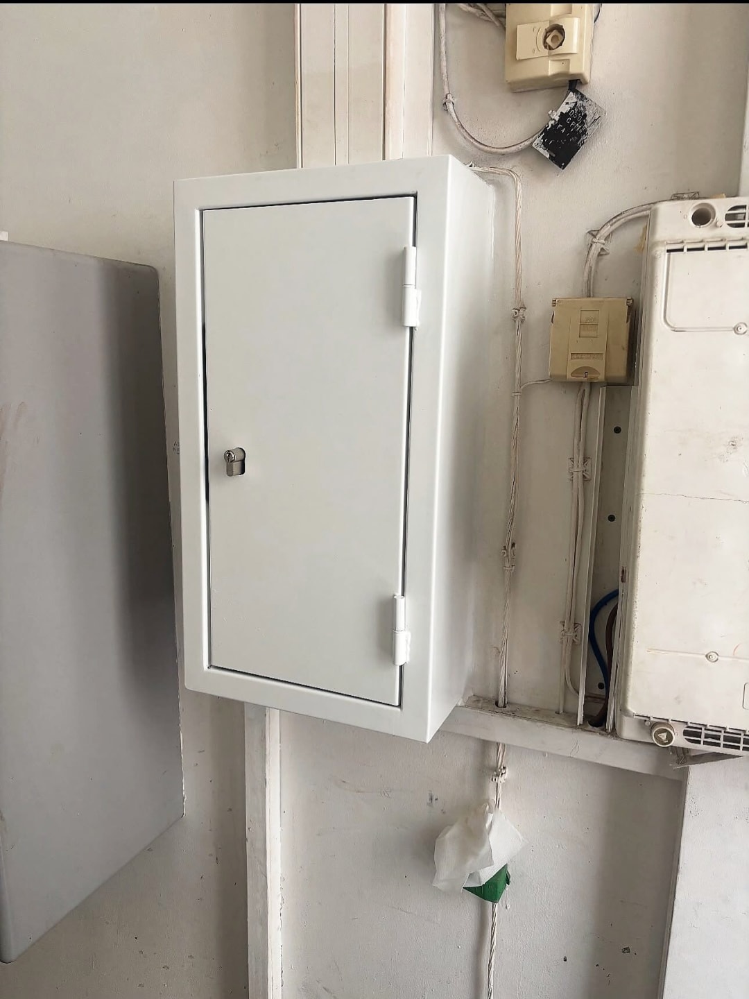 Coffret technique blanc fermant à clé, fixé au mur