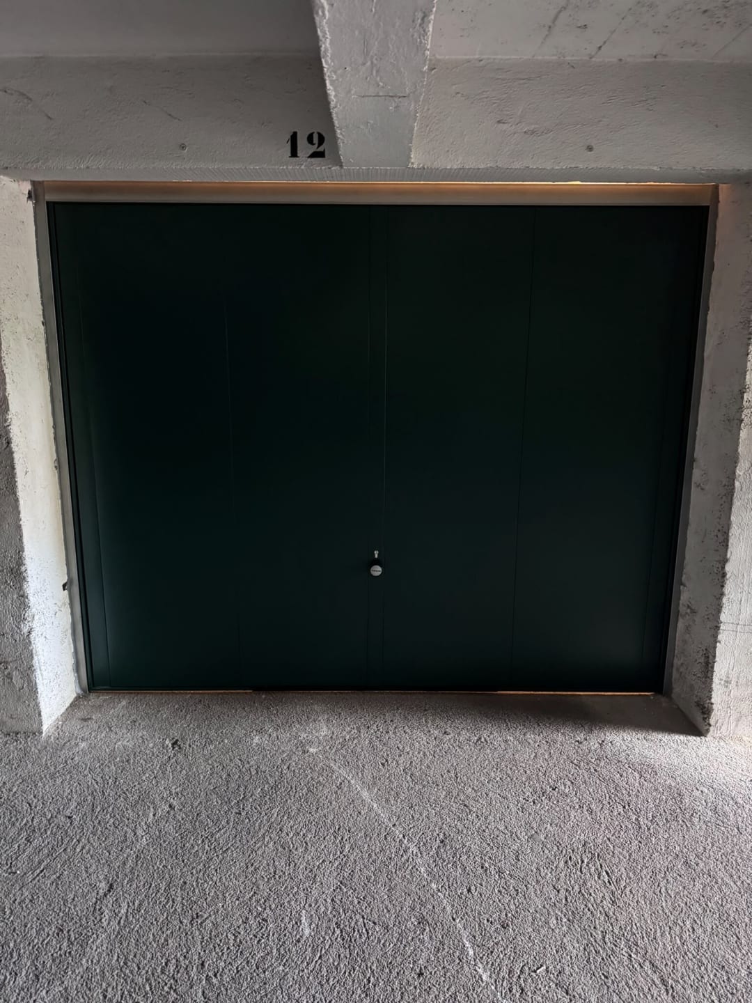 Porte de garage basculante verte fermant un box