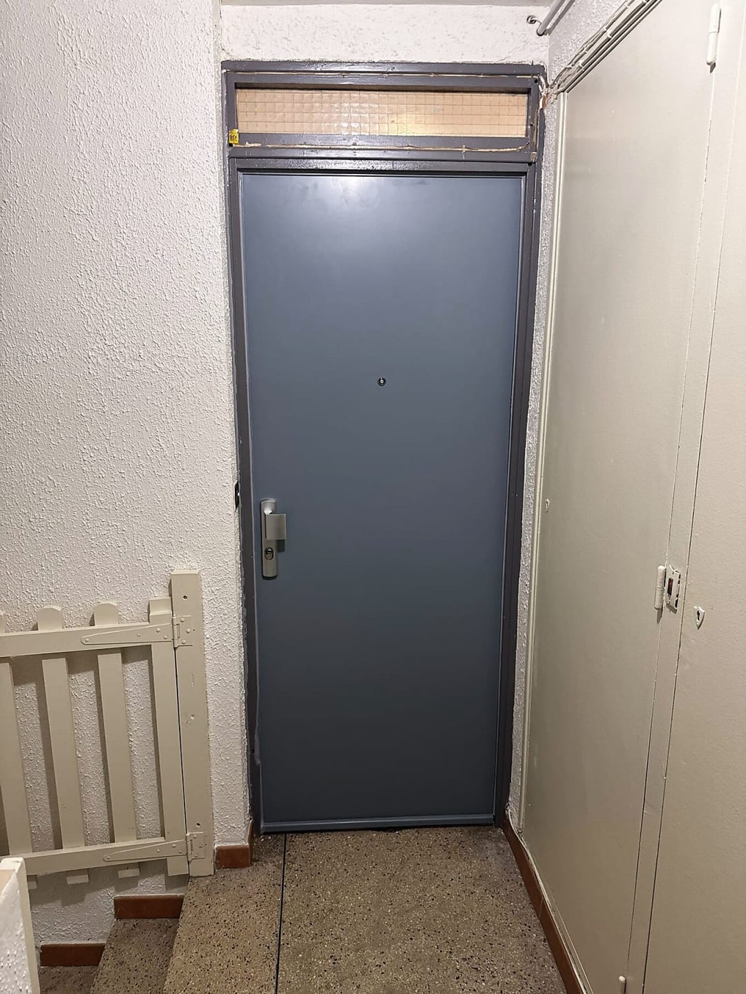 Porte métallique grise au fond d’un couloir