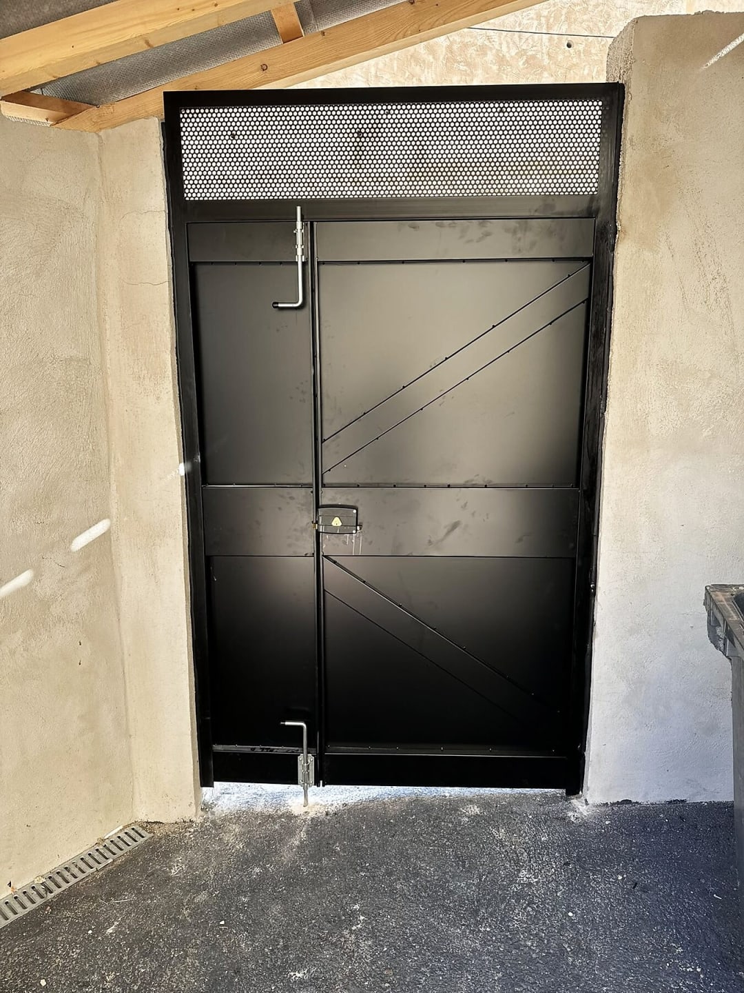 Porte de local poubelle en acier noir, à deux vantaux, avec imposte grillagée