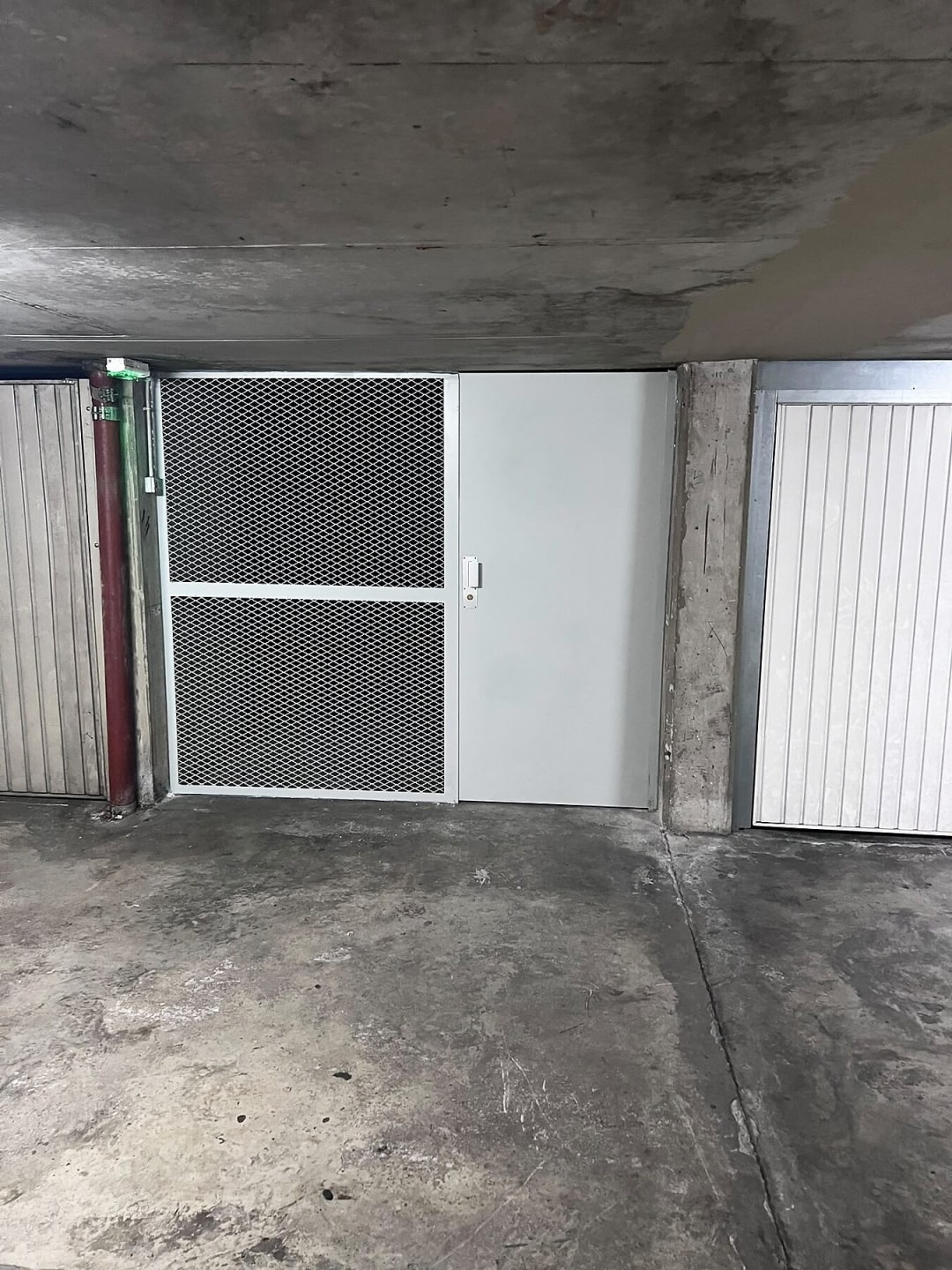 Portillon grillagé fermant un box en sous-sol