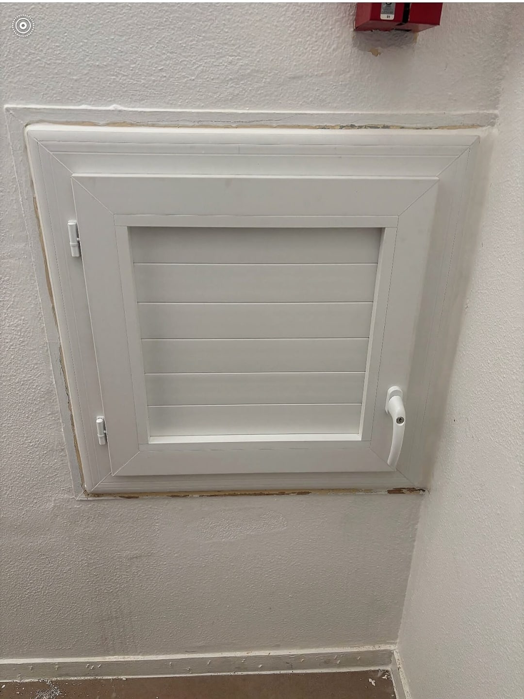 Trappe de visite blanche à lames posée dans un mur