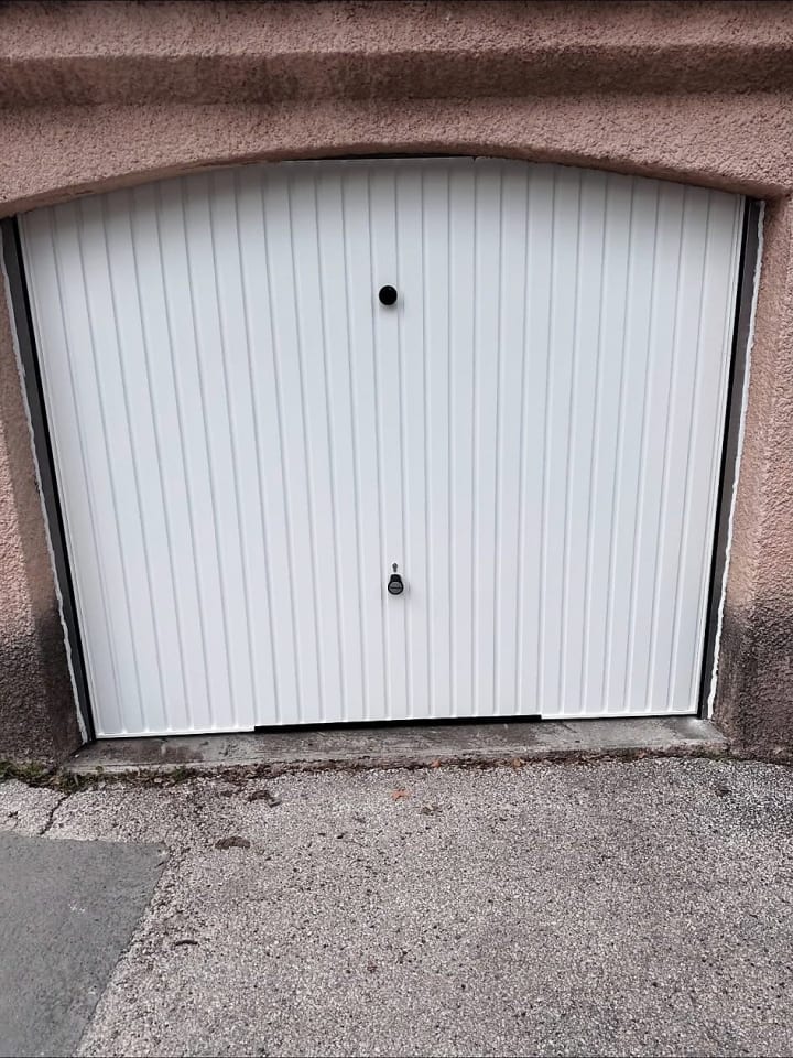 Porte de garage blanche sous un linteau cintré