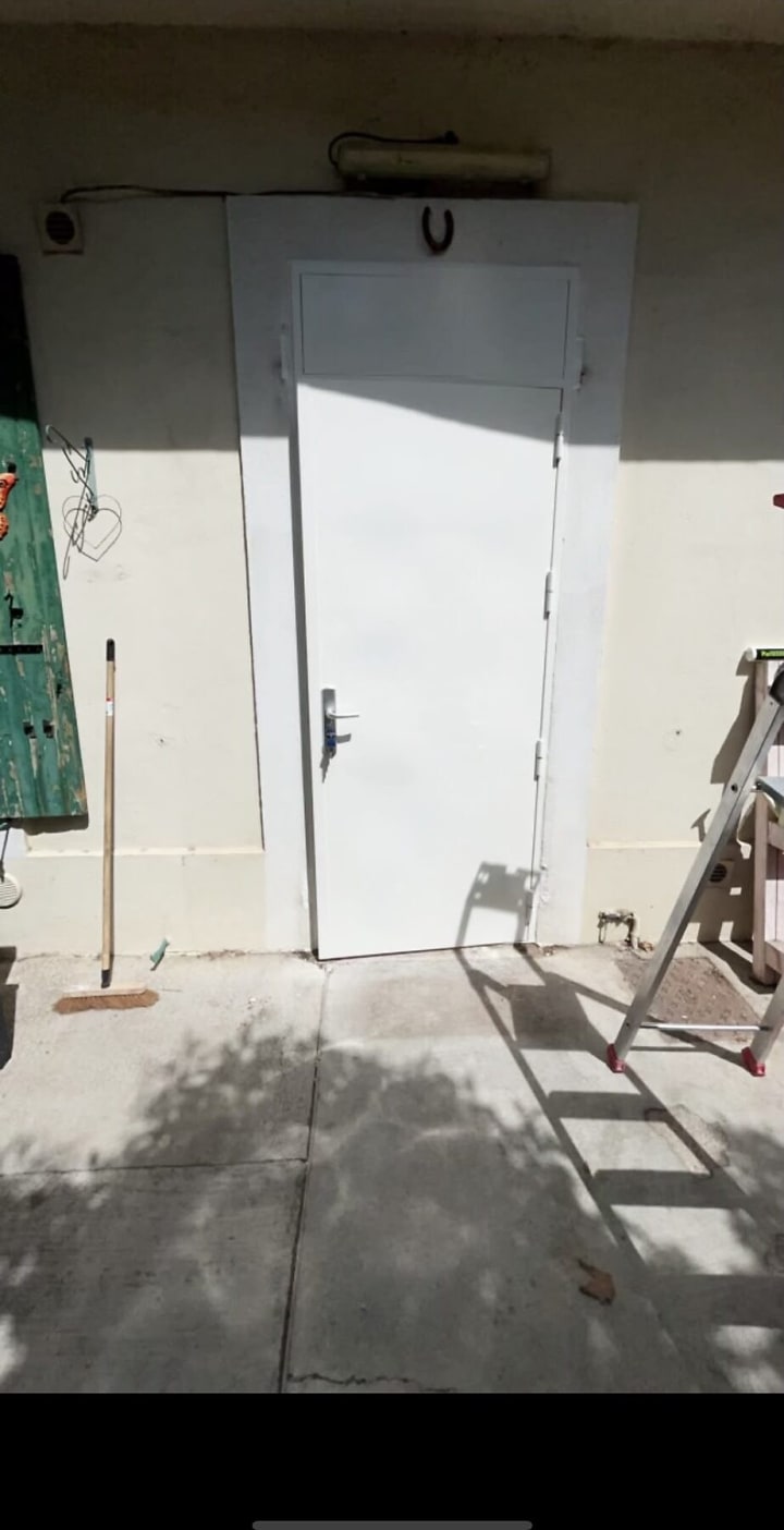 Porte métallique blanche de local technique, en extérieur