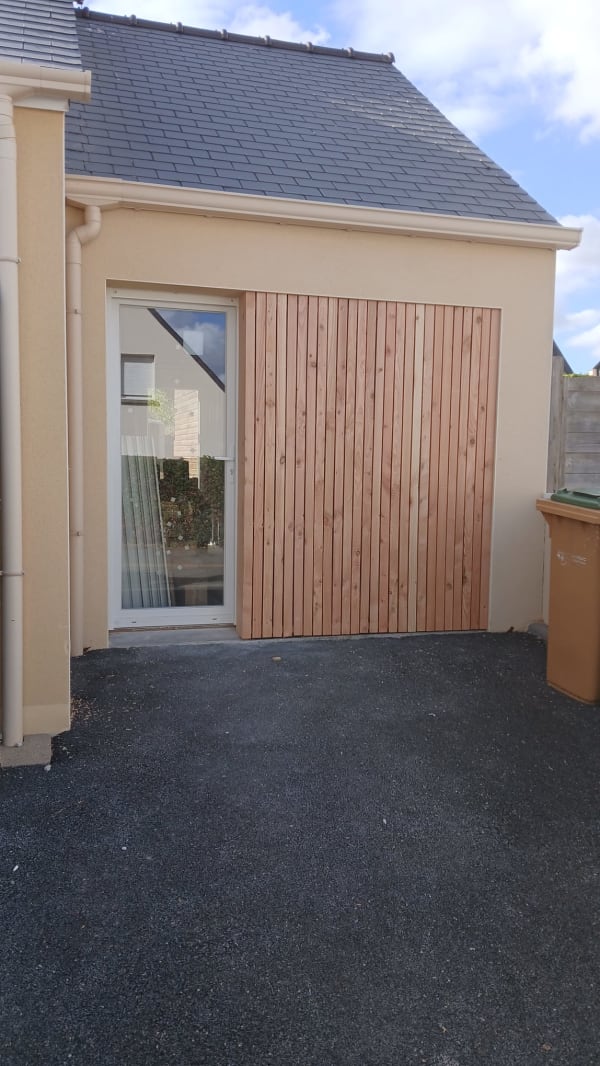 Porte de garage transformée en porte de service avec bardage bois