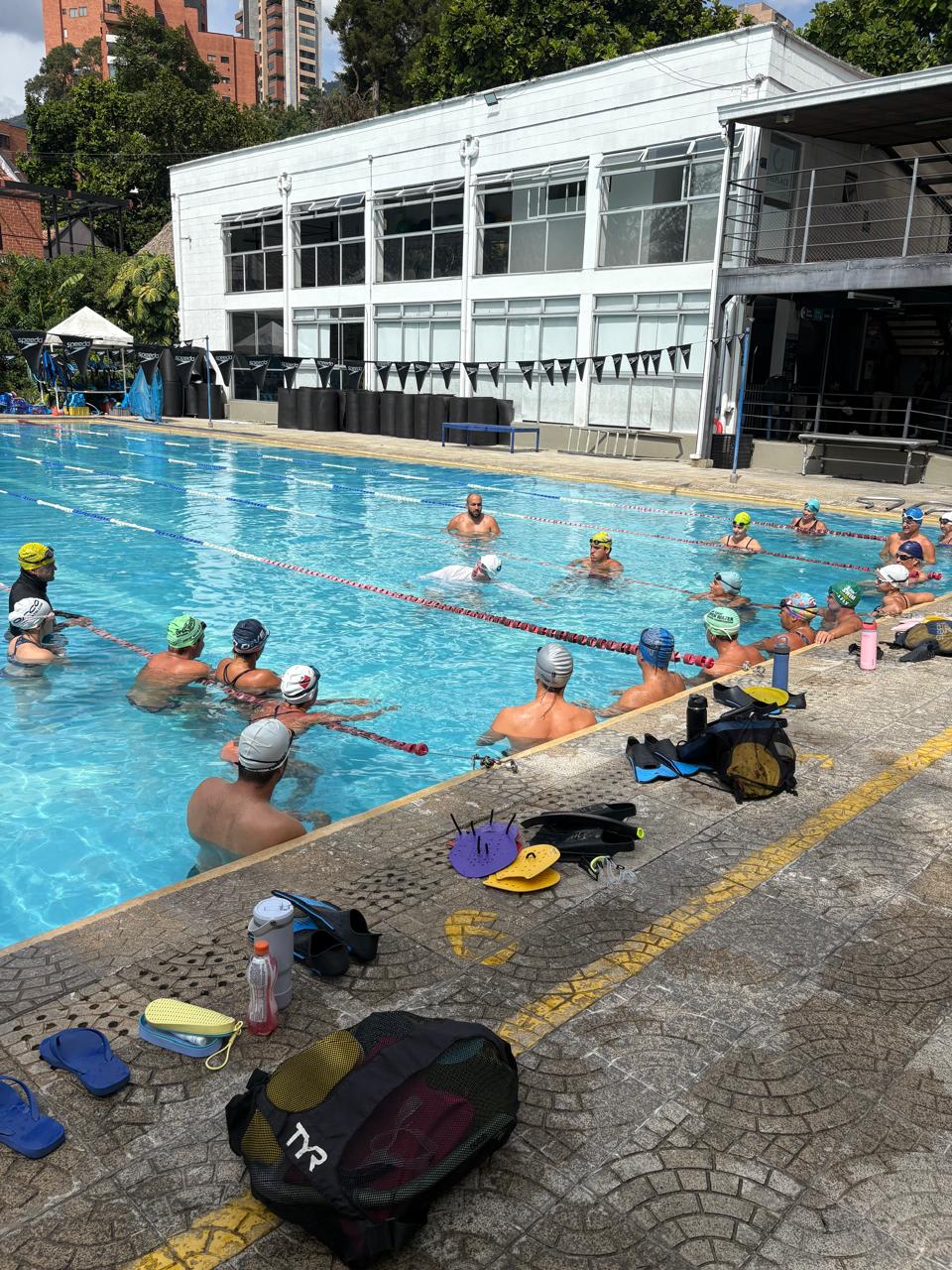 entrenador demostrando aspectos de la brazada de libre en un evento diurno de natación