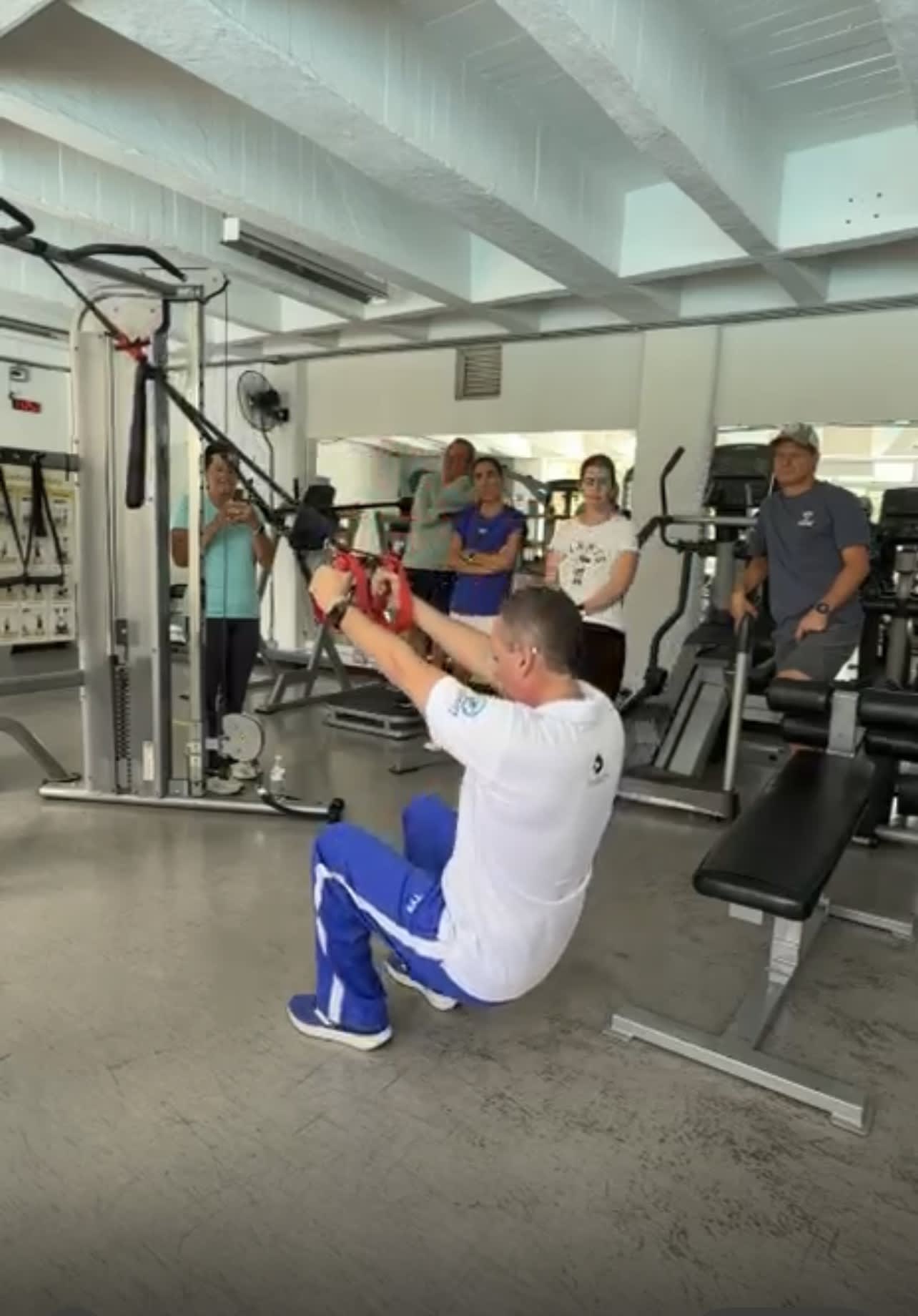 entrenador demostrando un ejercicio para el fortalecimiento de las piernas