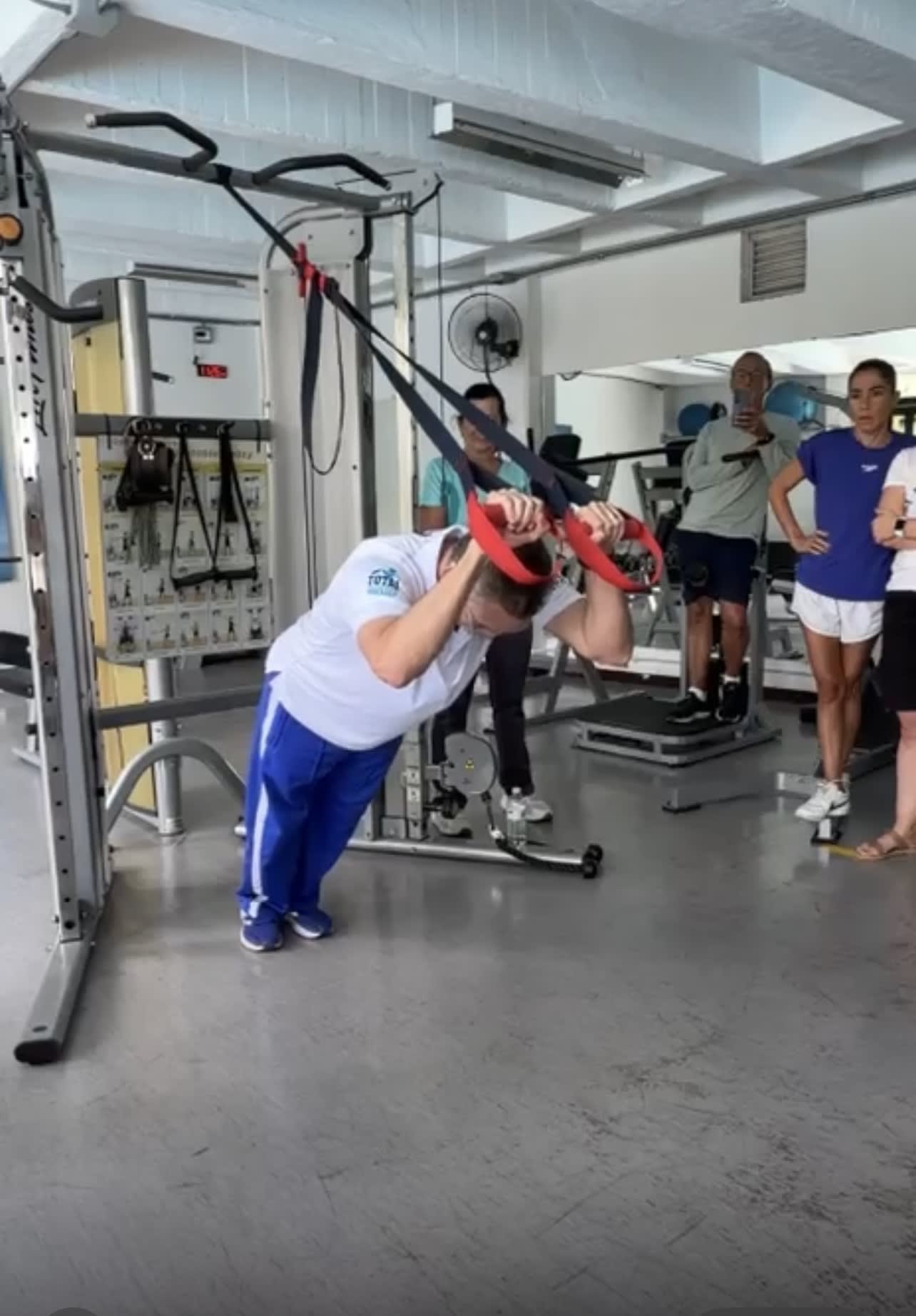 entrenador demostrando un movimiento para el fortalecimiento de los tríceps