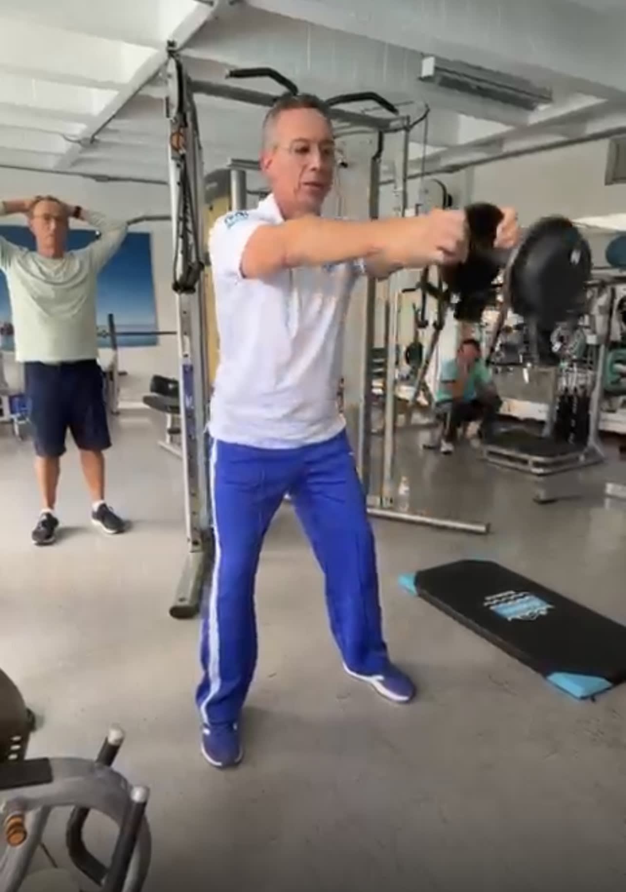 entrenador demostrando movimiento específico de fortalecimiento para la natación