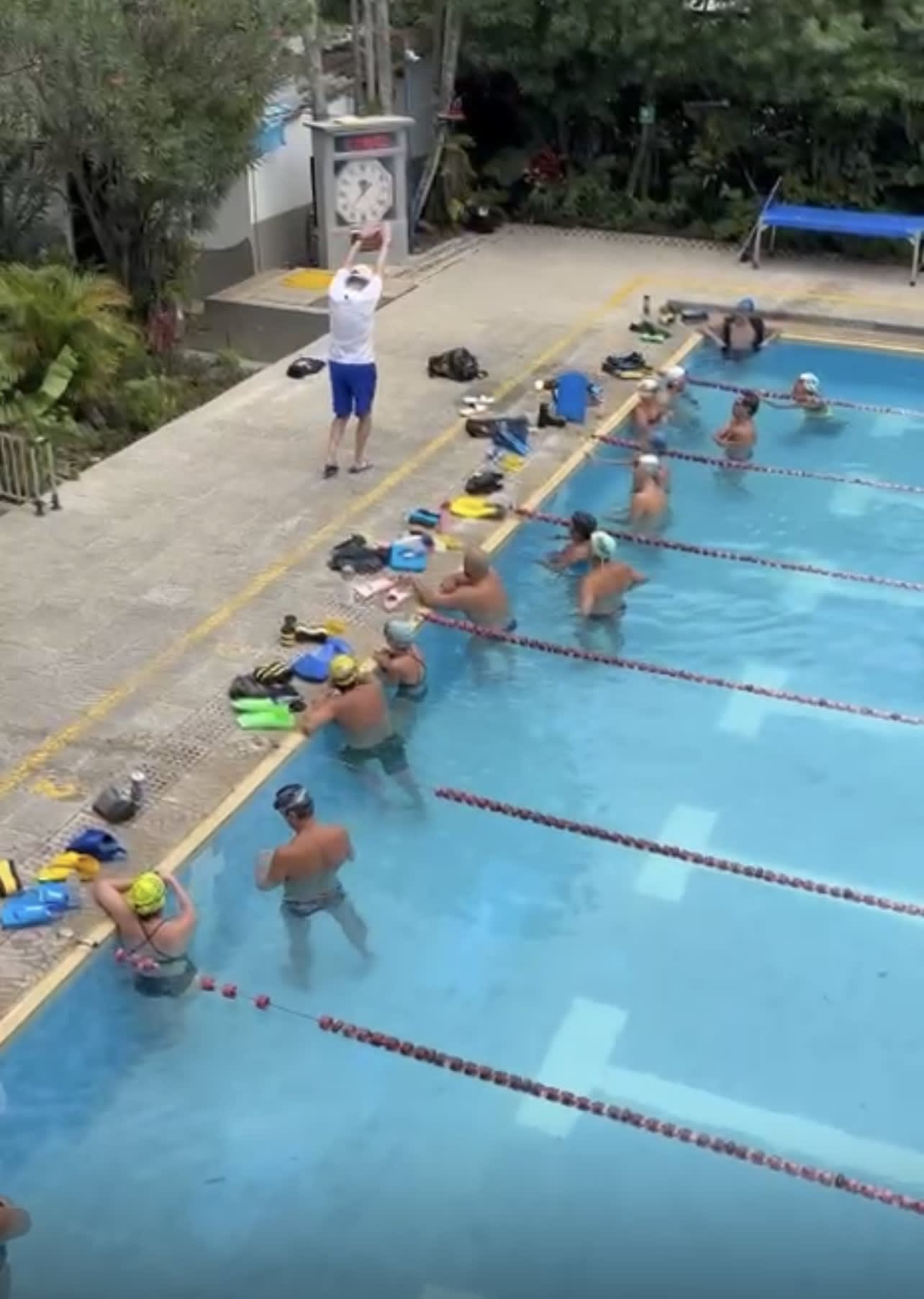 entrenador demostrando la posición correcta de los brazos al final de la brazada en el estilo pecho