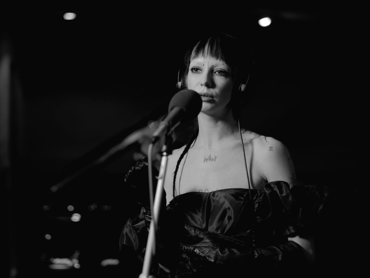 Bambie Thug at the microphone in a darkened studio, filmed in black and white by We Stream